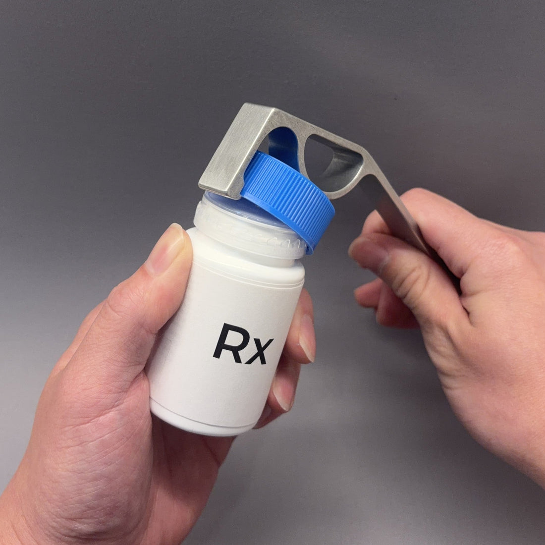 DCAPer childproof pill bottle opener in action — lever mechanism opening Rx medicine bottle cap