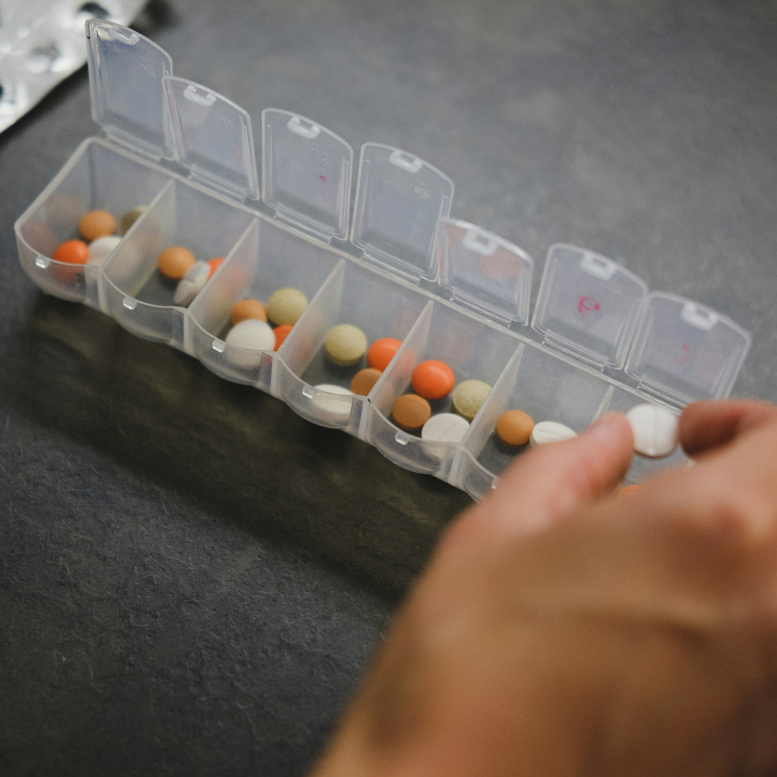 Senior man reviewing Medicare prescription paperwork at a desk with multiple medication bottles